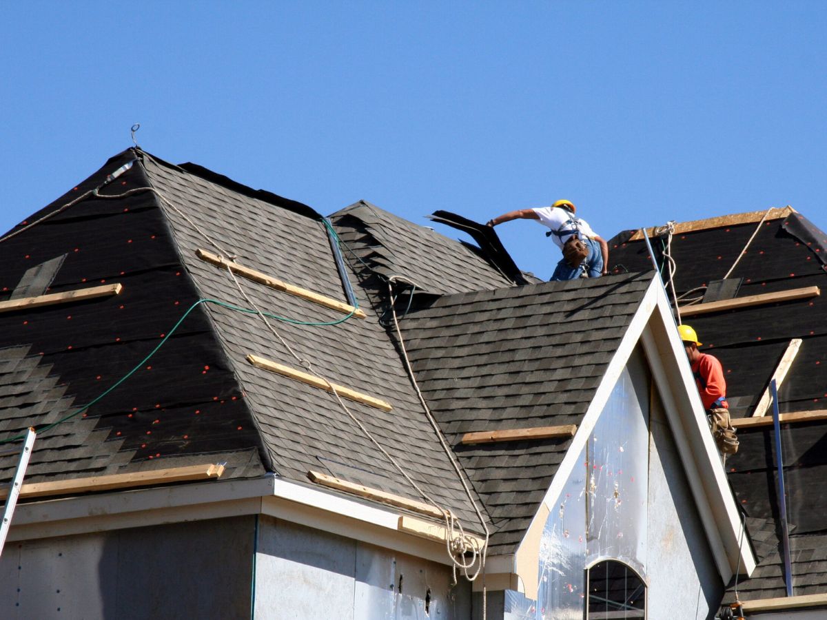 Roof repair near me in Newtown Square, PA showing a team repairing shingles after a windstorm