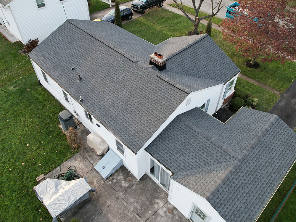 Roof repair services in Newtown Square, PA fixing a leaking roof on a colonial-style house